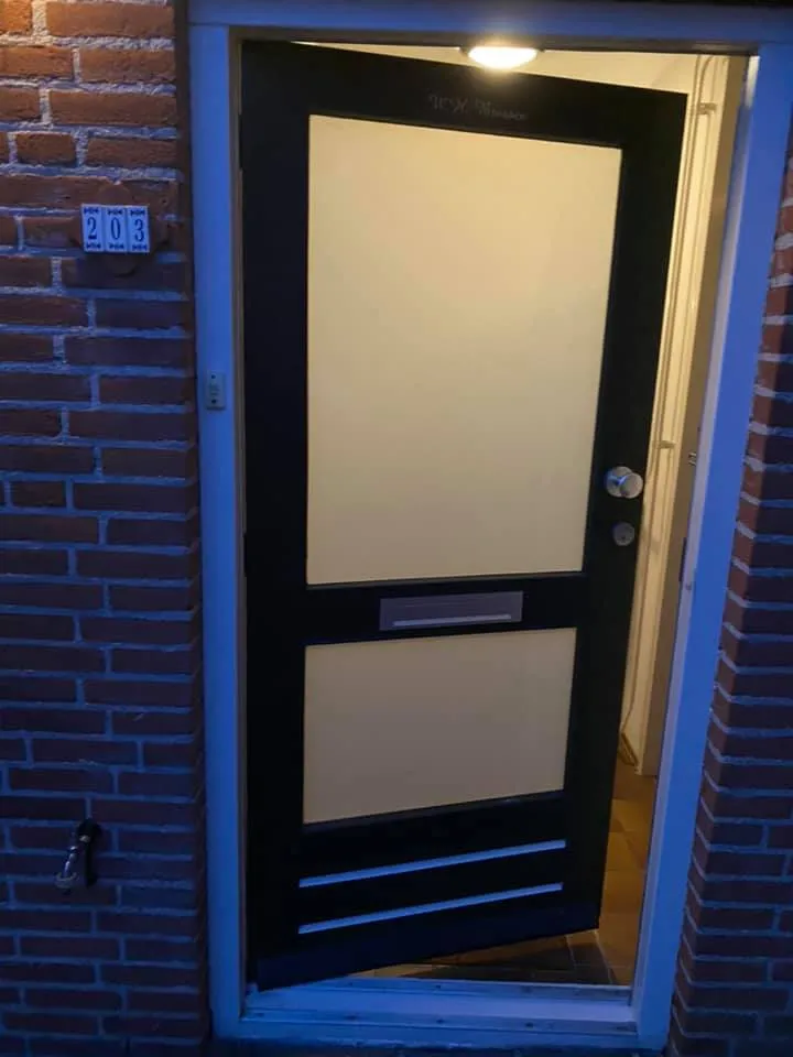 Moderne voordeur geschilderd in zwart met crème panelen